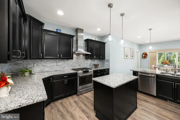 a kitchen with stainless steel appliances granite countertop sink stove top oven and microwave