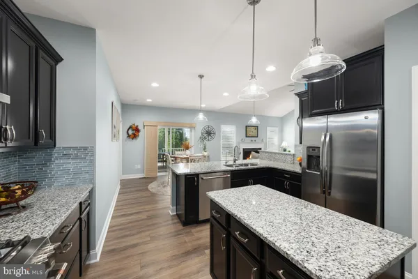 a kitchen with kitchen island a counter top space a sink appliances and cabinets