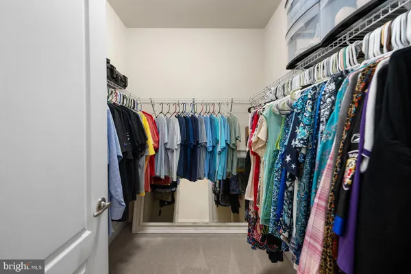 a view of walk in closet with clothes and shoes