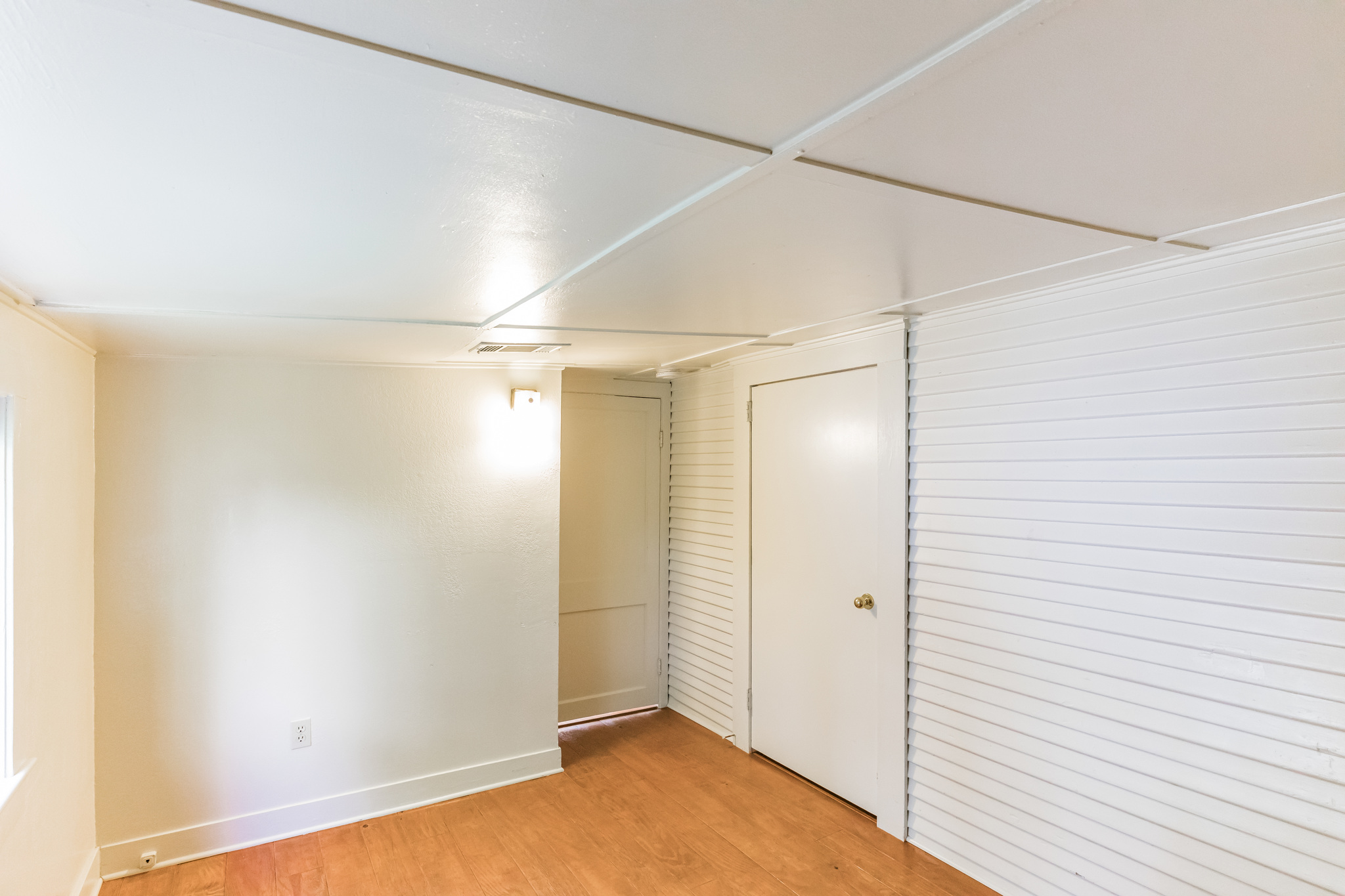 501 East 4th Street Georgetown, TX 78626 - Photo 21 of 25 Basement featuring light wood-type flooring and wood walls