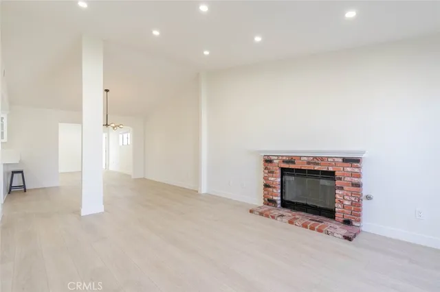 an empty room with fireplace and fan