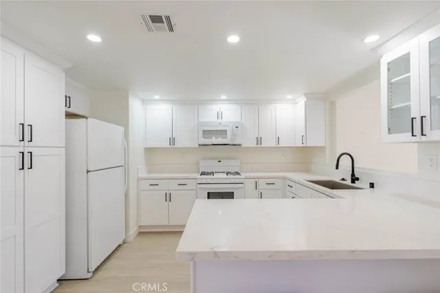 a kitchen with a sink a refrigerator and cabinets