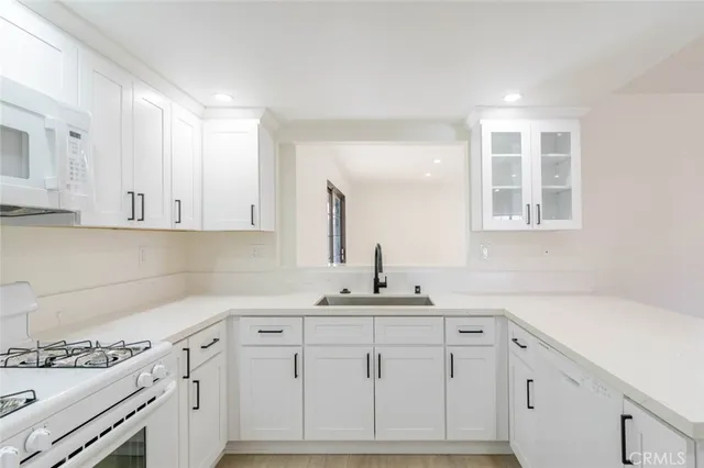 a kitchen with stainless steel appliances white cabinets and a window