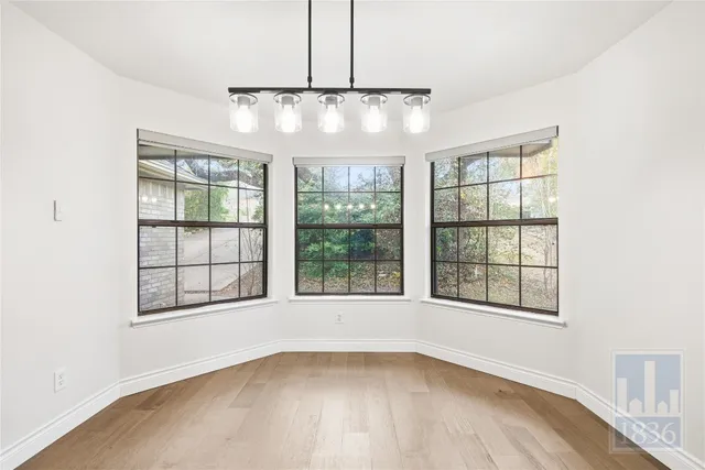 a view of a hallway to the room and a kitchen