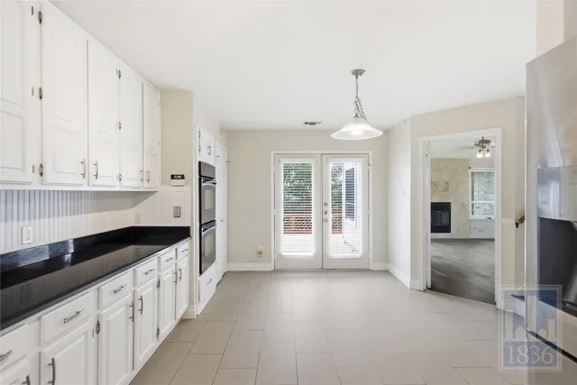 a kitchen with granite countertop white cabinets white stainless steel appliances and a refrigerator
