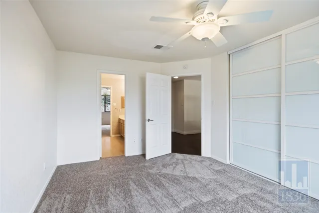 an empty room with a ceiling fan and window