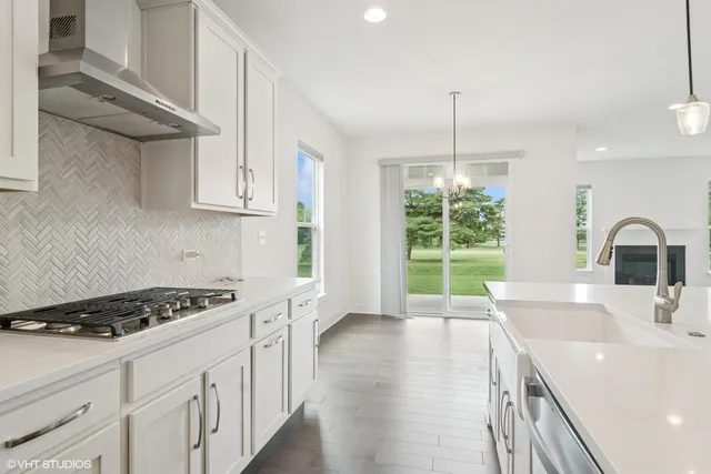 a kitchen with kitchen island a sink appliances cabinets and a large window