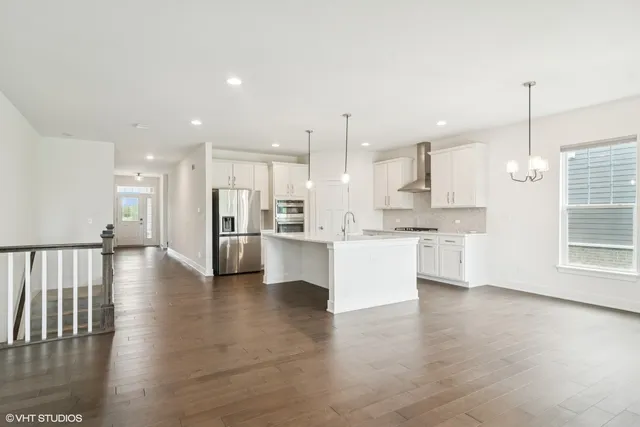 a view of kitchen with kitchen island white cabinets wooden floor and center island