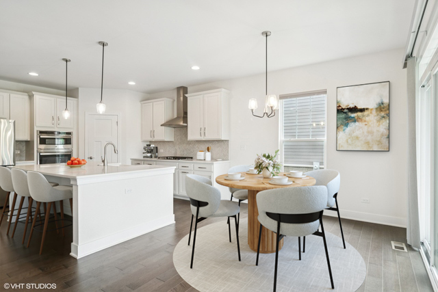 23068 Pinehurst Drive Kildeer, IL 60047 - Photo 5 of 30 a kitchen with kitchen island granite countertop a table chairs a sink dishwasher window and cabinets