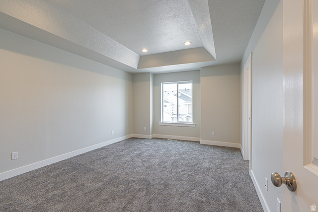 2249 South 1090 West, Unit 76 Nibley, UT 84321 - Photo 15 of 19 Spacious room featuring a tray ceiling with recessed lighting, gray carpet flooring, and a large window with white trim