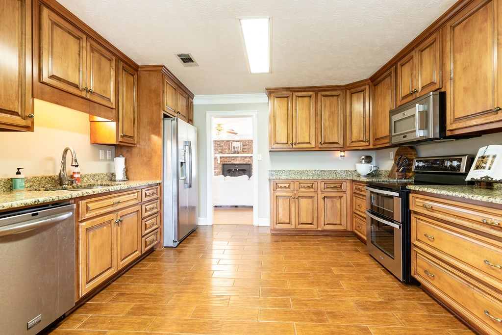 336 Clark Road Seale, AL 36875 - Photo 25 of 66 a kitchen with stainless steel appliances granite countertop a stove a sink and a refrigerator