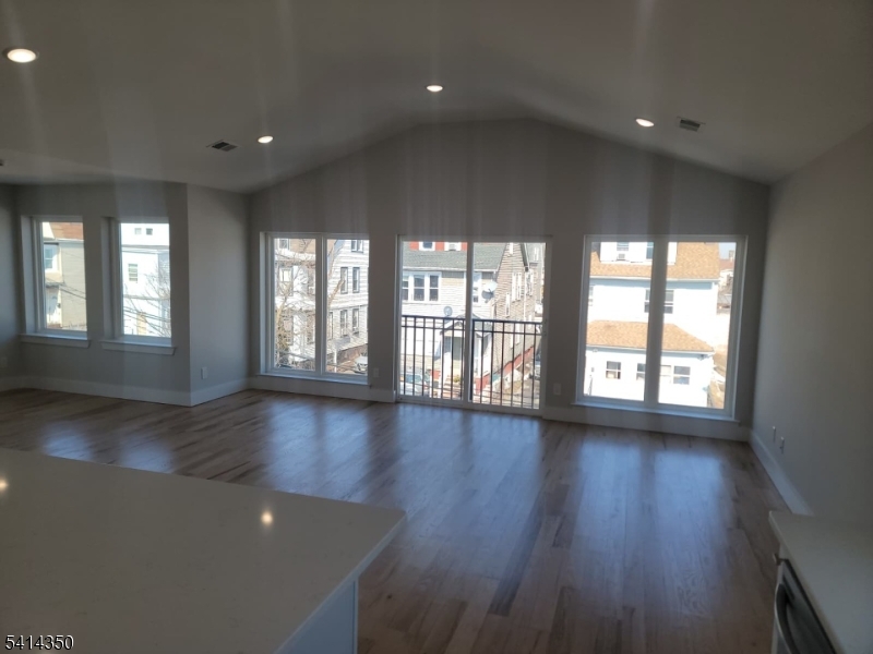 118 Shephard Avenue Newark, NJ 07112 - Photo 12 of 15 an empty room with wooden floor and windows
