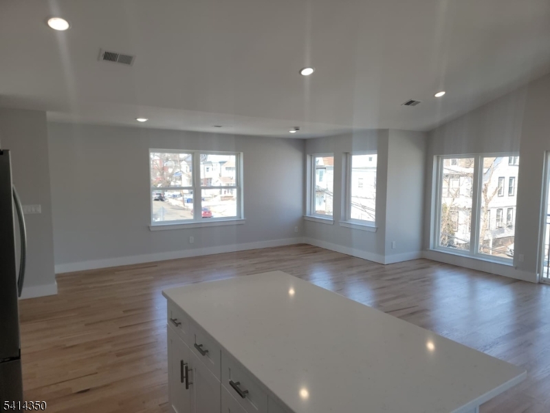 118 Shephard Avenue Newark, NJ 07112 - Photo 13 of 15 an empty room with wooden floor and windows