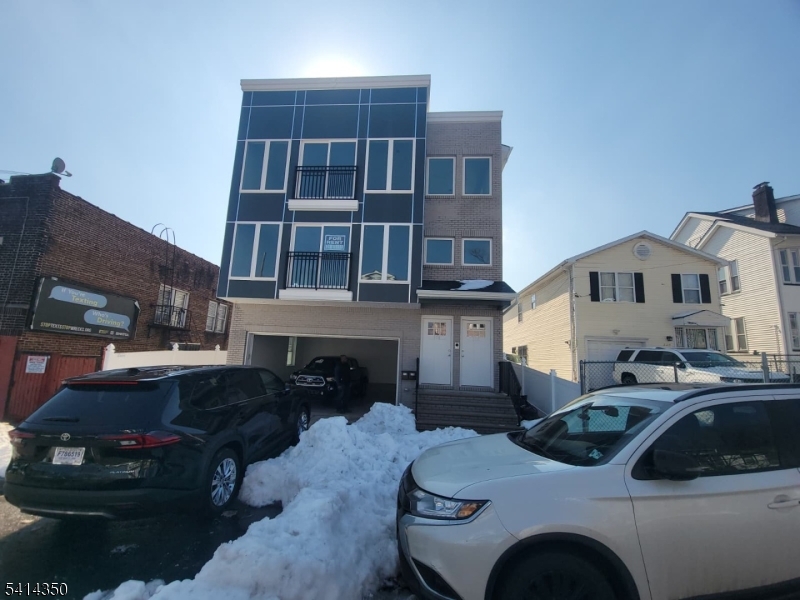 118 Shephard Avenue Newark, NJ 07112 - Photo 3 of 15 a front view of a house with cars parked