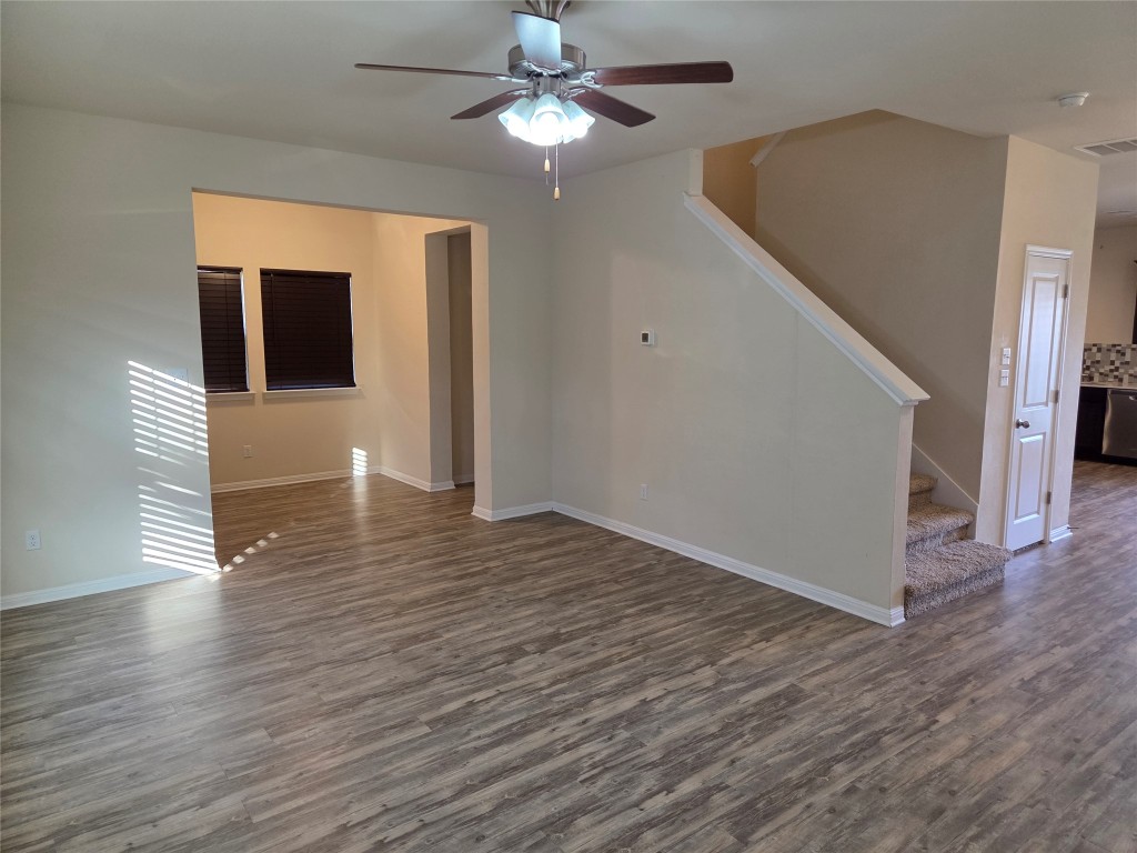 8136 Daisy Cutter Crossing Georgetown, TX 78626 - Photo 12 of 27 a view of a livingroom with wooden floor a ceiling fan and windows