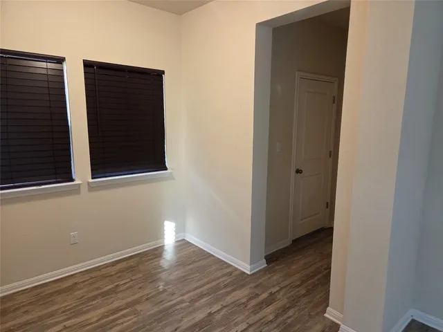 a view of a small space with wooden floor and a window