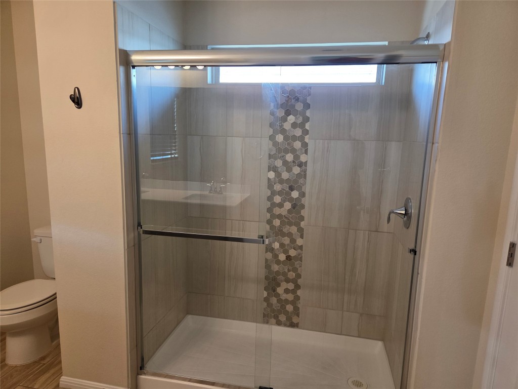 8136 Daisy Cutter Crossing Georgetown, TX 78626 - Photo 23 of 27 a bathroom with a glass shower door