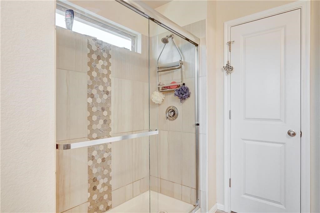 8136 Daisy Cutter Crossing Georgetown, TX 78626 - Photo 4 of 27 a bathroom with a glass shower door