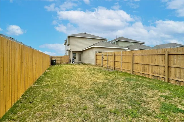 a view of a backyard with brick wall and fence