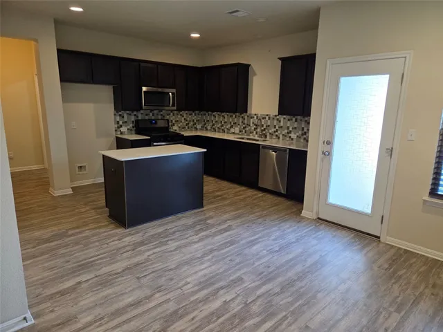 a kitchen with a wooden floor and a sink