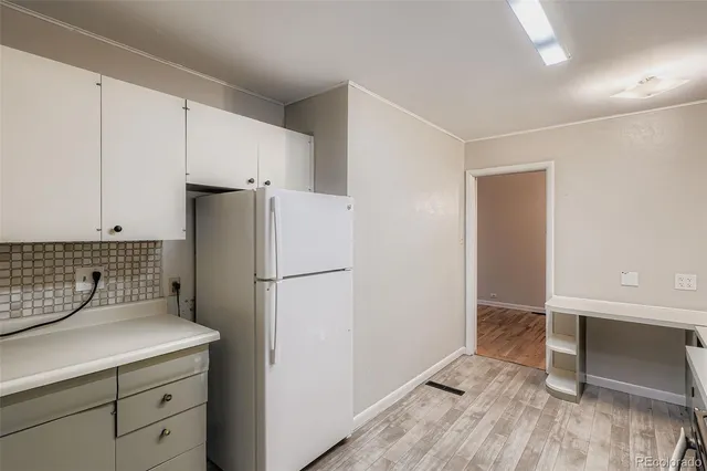 a kitchen with a refrigerator sink stove and cabinets