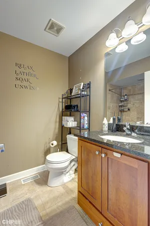 a bathroom with a granite countertop sink a toilet and a mirror