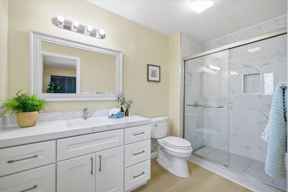 7109 Elba Way Dublin, CA 94568 - Photo 42 of 60 a bathroom with a granite countertop sink a toilet a large mirror and shower