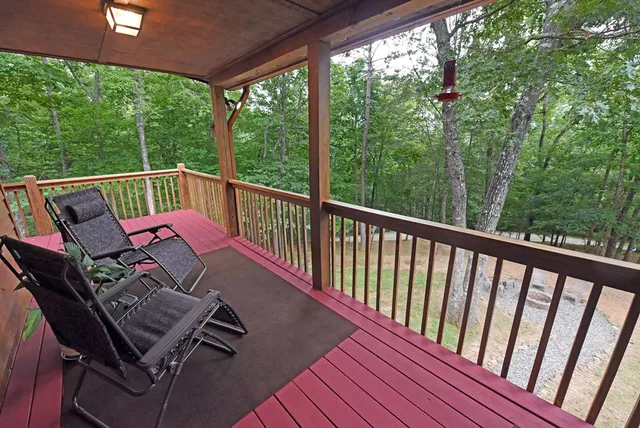 a bedroom with a bed next to a large window with wooden floor