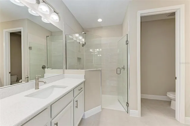 a bathroom with a sink shower and a mirror