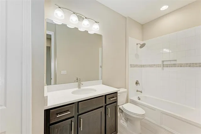 a bathroom with a sink a toilet a mirror a vanity and bathtub