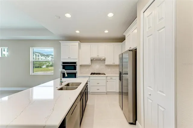 a kitchen with white cabinets and stainless steel appliances