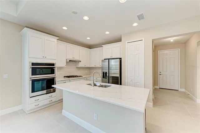 a kitchen with stainless steel appliances kitchen island sink stove and refrigerator