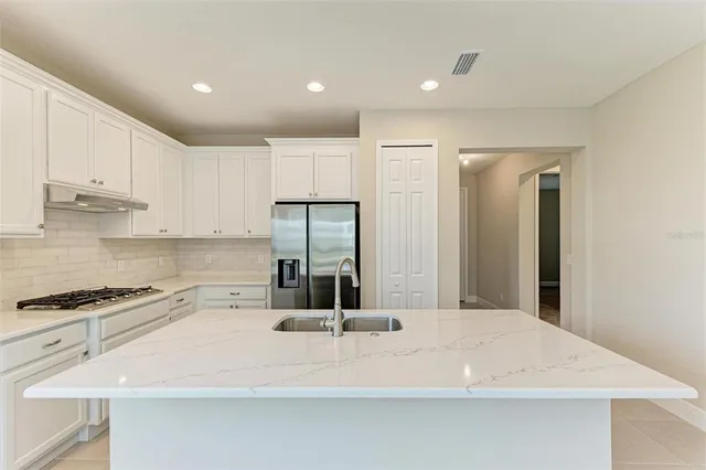 a kitchen with a sink a refrigerator and cabinets