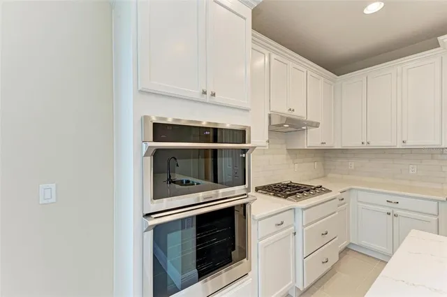 a kitchen with white cabinets and appliances