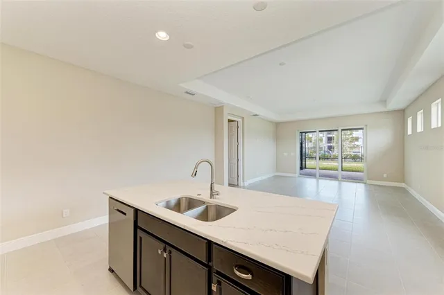 a kitchen with a sink a counter space and a refrigerator