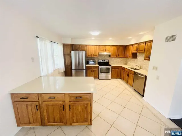 a kitchen with stainless steel appliances granite countertop a sink and a refrigerator