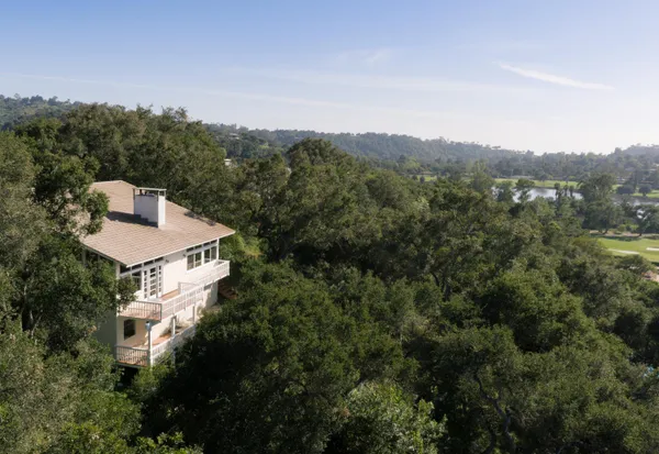 an aerial view of a house with a yard and mountain