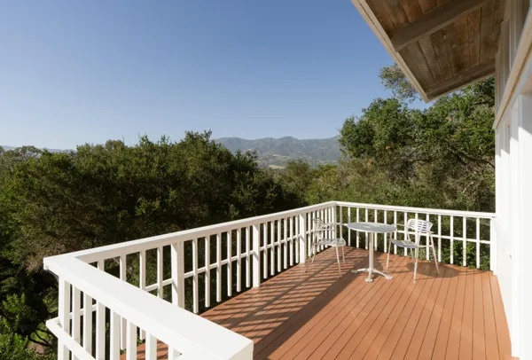 a view of balcony with wooden floor and fence
