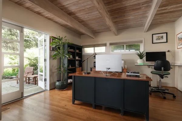 a view of a workspace with furniture and wooden floor