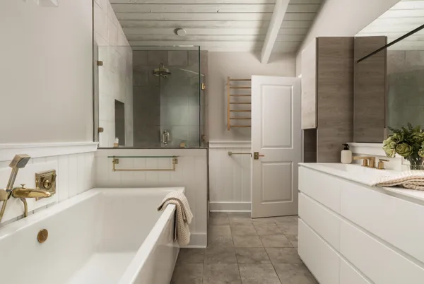a bathroom with a tub sink and mirror