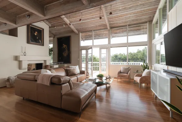 a living room with fireplace furniture and a large window