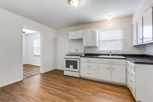 a kitchen with granite countertop white cabinets and white appliances