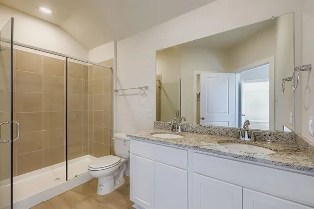 a bathroom with a granite countertop sink toilet and shower