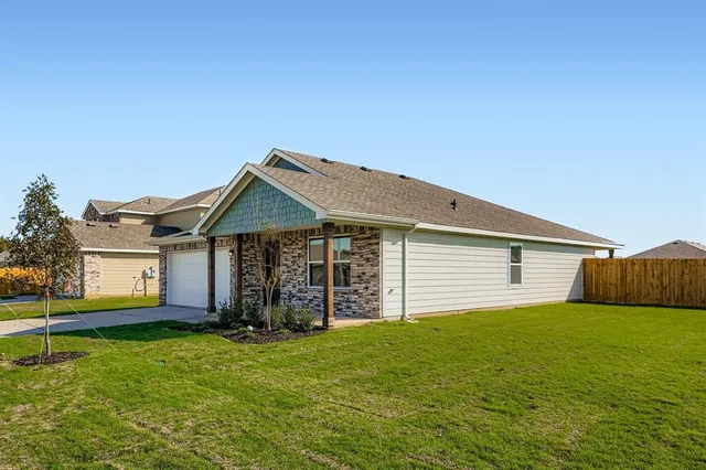 a view of a house with a yard and fence