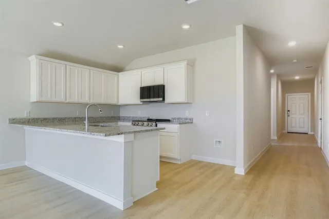 a kitchen with stainless steel appliances granite countertop a stove a sink and a refrigerator