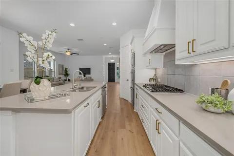 a kitchen with stainless steel appliances granite countertop a table chairs sink and cabinets