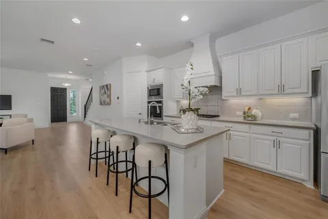 a kitchen with kitchen island stainless steel appliances a stove a sink a refrigerator and cabinets