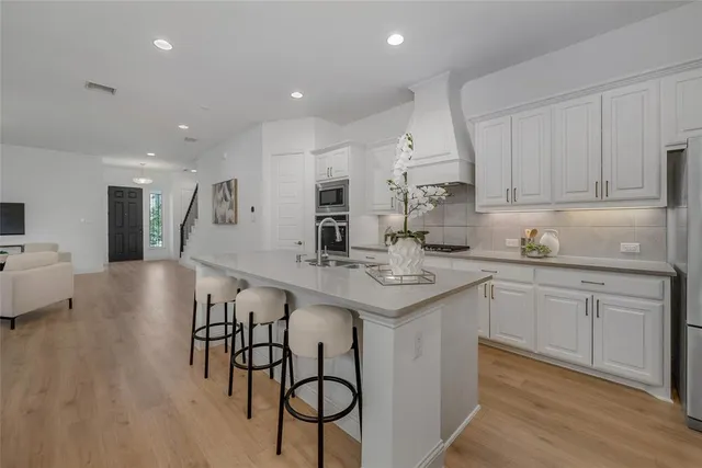 a kitchen with kitchen island stainless steel appliances a stove a sink a refrigerator and cabinets