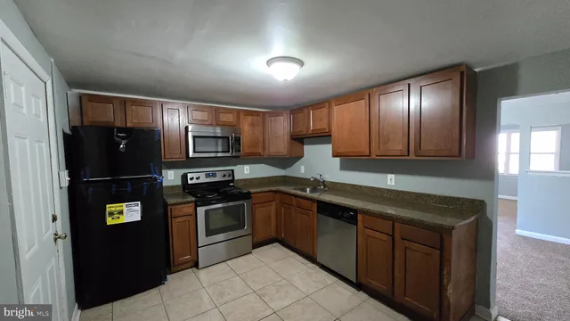 a kitchen with stainless steel appliances granite countertop a refrigerator and a sink