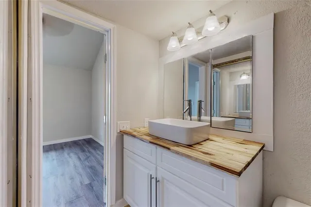 a bathroom with a granite countertop sink and a mirror